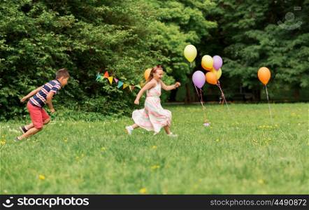 friendship, childhood, leisure and people concept - happy kids or friends playing tag game at birthday party in summer park. happy kids playing tag game at birthday party. happy kids playing tag game at birthday party