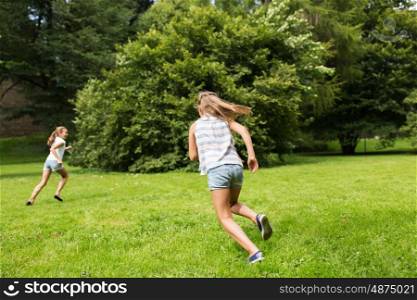 friendship, childhood, leisure and people concept - happy kids or friends playing catch-up game and running in summer park. happy kids or friends playing outdoors