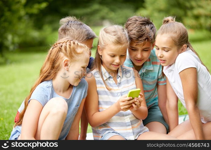 friendship, childhood, technology and people concept - group of happy kids or friends with smartphone in summer park