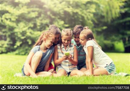 friendship, childhood, technology and people concept - group of happy kids or friends with smartphone in summer park. kids or friends with smartphone in summer park