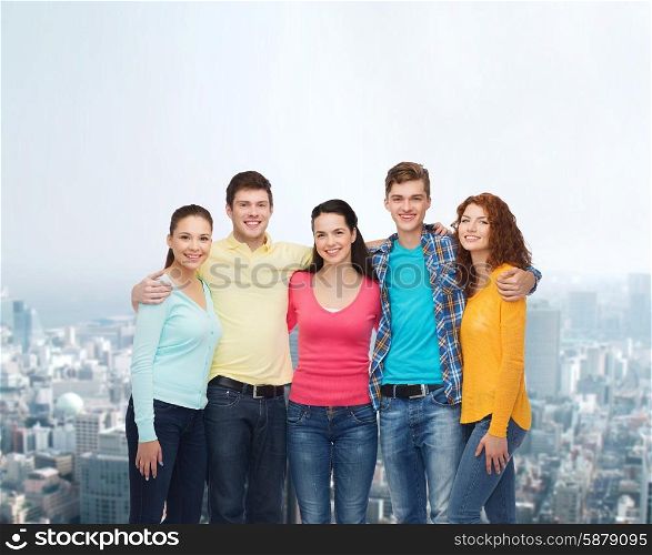 friendship, city life and people concept - group of smiling teenagers over city background