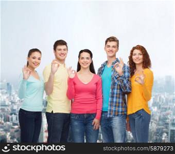 friendship, city life and people concept - group of smiling teenagers over city background
