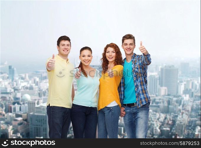 friendship, city life and people concept - group of smiling teenagers showing thumbs up over city background