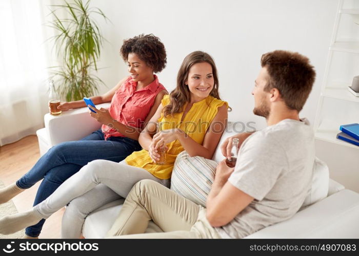 friendship, communication and people concept - group of happy friends drinking beer and talking at home. group of happy friends with beer talking at home