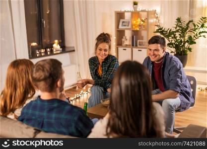 friendship, communication and people concept - group of happy friends drinking non-alcoholic beer at home. friends drinking non-alcoholic beer at home