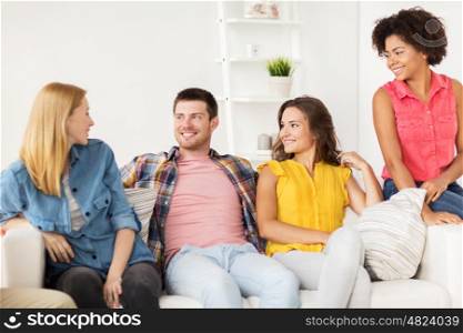 friendship, communication and people concept - group of happy friends talking at home