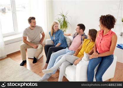 friendship, communication and people concept - group of happy friends talking at home