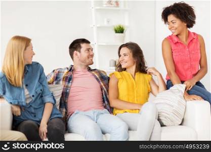 friendship, communication and people concept - group of happy friends talking at home. group of happy friends talking at home