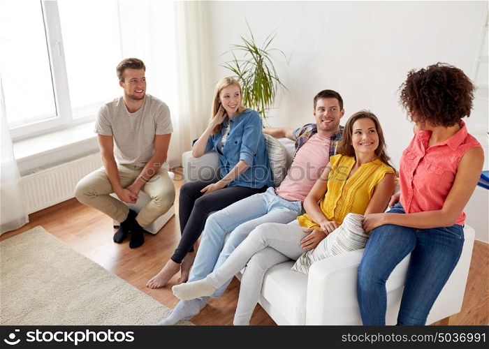 friendship, communication and people concept - group of happy friends talking at home. group of happy friends talking at home