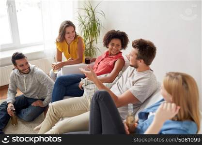 friendship, communication and people concept - group of happy friends with drinks talking at home. group of happy friends with drinks talking at home