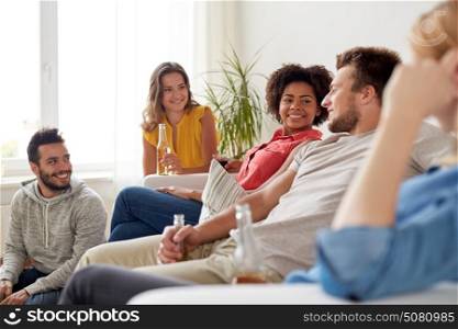 friendship, communication and people concept - group of happy friends with drinks talking at home. group of happy friends with drinks talking at home