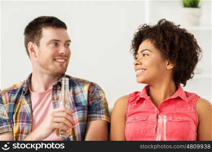 friendship, communication and people concept - happy friends or couple with beer talking at home