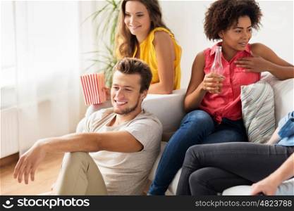 friendship, communication, people and entertainment concept - happy friends with beer and popcorn talking and watching tv at home