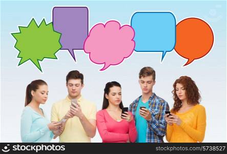 friendship, communication, technology and people concept - smiling friends showing blank smartphones screens over blue background with doodles