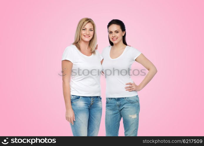 friendship, diverse, body positive and people concept - group of happy different women in white t-shirts hugging over pink background