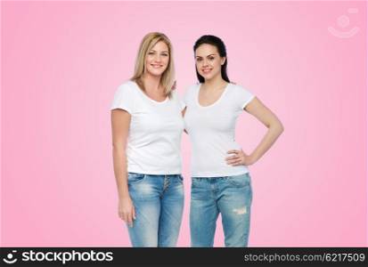 friendship, diverse, body positive and people concept - group of happy different women in white t-shirts hugging over pink background