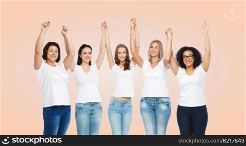 friendship, diverse, body positive and people concept - group of happy different size women in white t-shirts holding hands up over beige background
