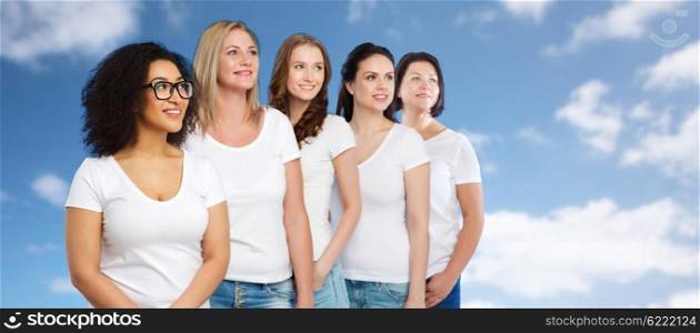 friendship, diverse, body positive and people concept - group of happy different size women in white t-shirts over blue sky and clouds background