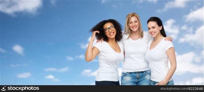 friendship, diverse, body positive and people concept - group of happy different size women in white t-shirts hugging over blue sky and clouds background