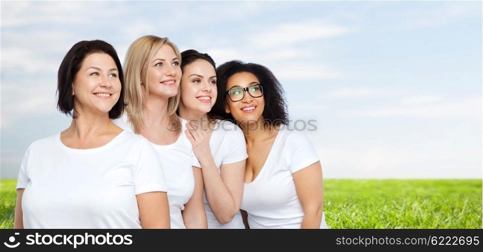 friendship, diverse, body positive and people concept - group of happy different size women in white t-shirts over blue sky and grass background
