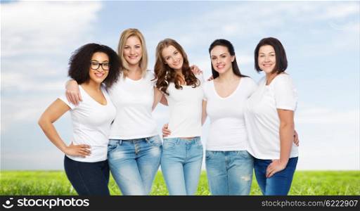 friendship, diverse, body positive and people concept - group of happy different size women in white t-shirts hugging over blue sky and grass background
