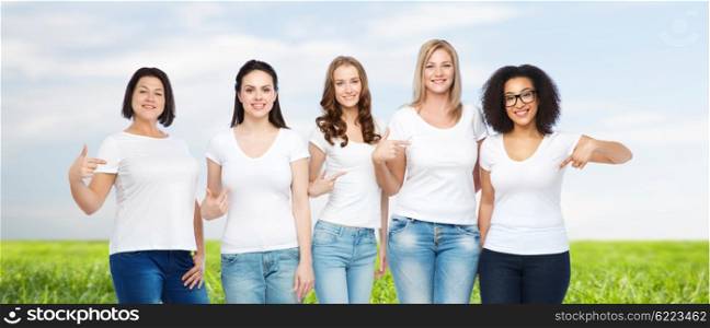 friendship, diverse, body positive and people concept - group of happy different size women in white t-shirts pointing finger to themselves over blue sky and grass background