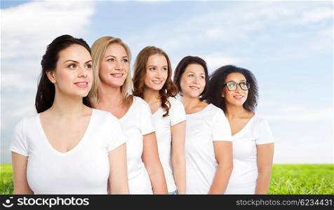 friendship, diverse, body positive and people concept - group of happy different size women in white t-shirts over blue sky and grass background