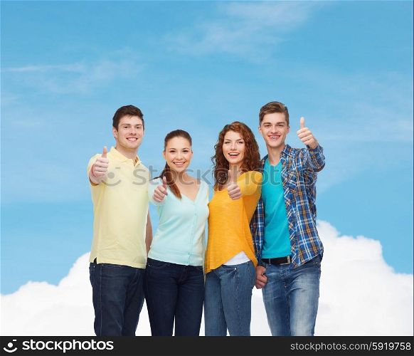 friendship, dream, future and people concept - group of smiling teenagers showing thumbs up over blue sky with white cloud background