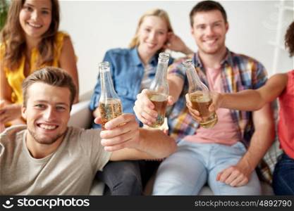 friendship, drink, alcohol, holidays and people concept - happy friends drinking beer at home party