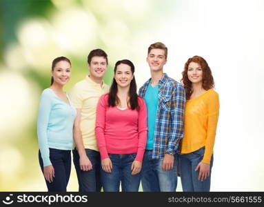 friendship, ecology and people concept - group of smiling teenagers standing over green background