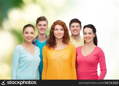 friendship, ecology and people concept - group of smiling teenagers standing over green background