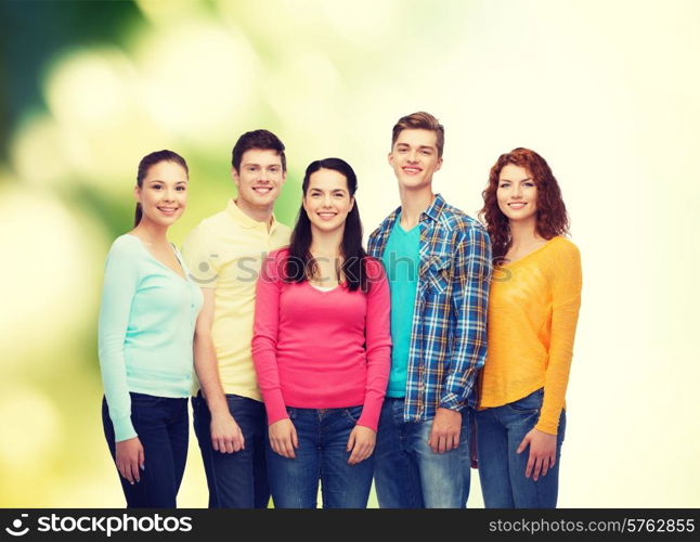 friendship, ecology and people concept - group of smiling teenagers standing over green background