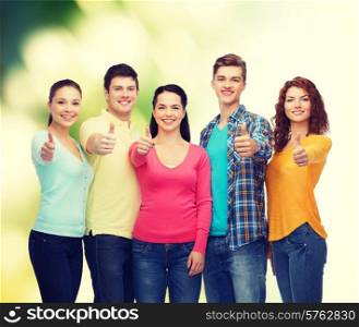 friendship, ecology, gesture and people concept - group of smiling teenagers showing thumbs up over green background