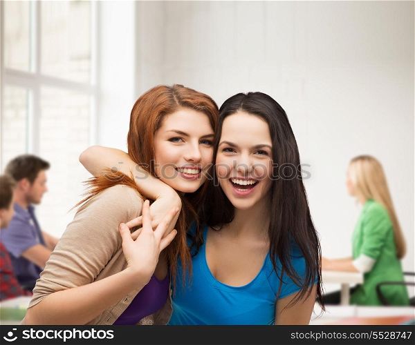 friendship, education and happy people concept - two laughing girls hugging