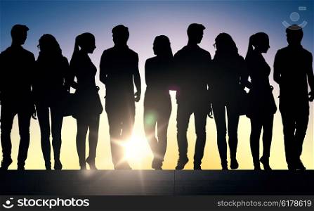 friendship, education and people concept - silhouettes of friends or students on stairs over sun