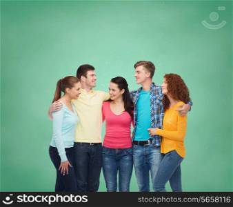 friendship, education, school and people concept - group of smiling teenagers standing over green board background