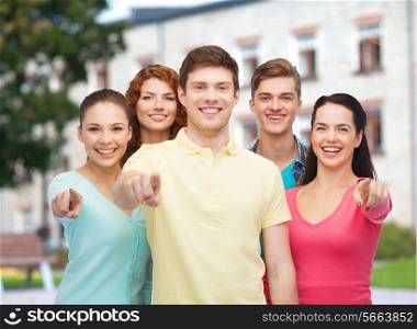 friendship, education, summer vacation and people concept - group of smiling teenagers pointing finger on you over campus background