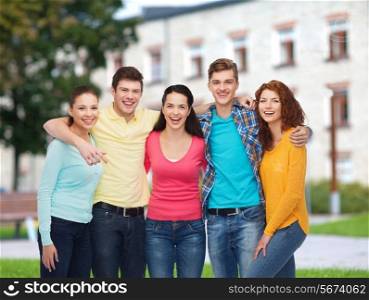 friendship, education, summer vacation and people concept - group of smiling teenagers standing and hugging over campus background