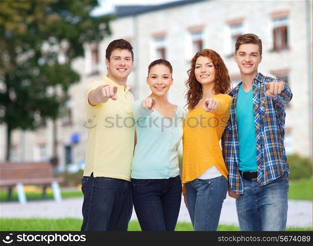 friendship, education, summer vacation and people concept - group of smiling teenagers pointing finger on you over campus background