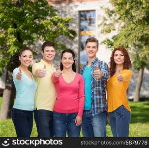 friendship, education, summer vacation and people concept - group of smiling teenagers showing thumbs up over campus background