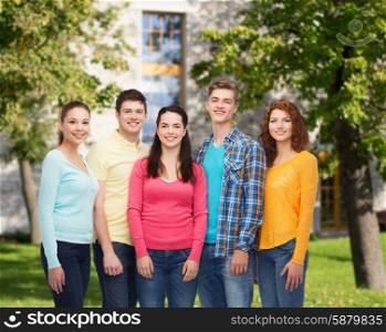 friendship, education, summer vacation and people concept - group of smiling teenagers standing over campus background