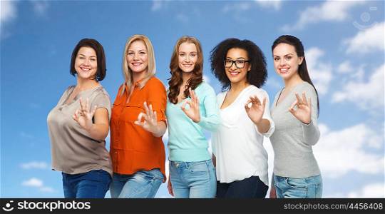 friendship, fashion, body positive, gesture and people concept - group of happy different size women in casual clothes showing ok hand sign over blue sky and clouds background