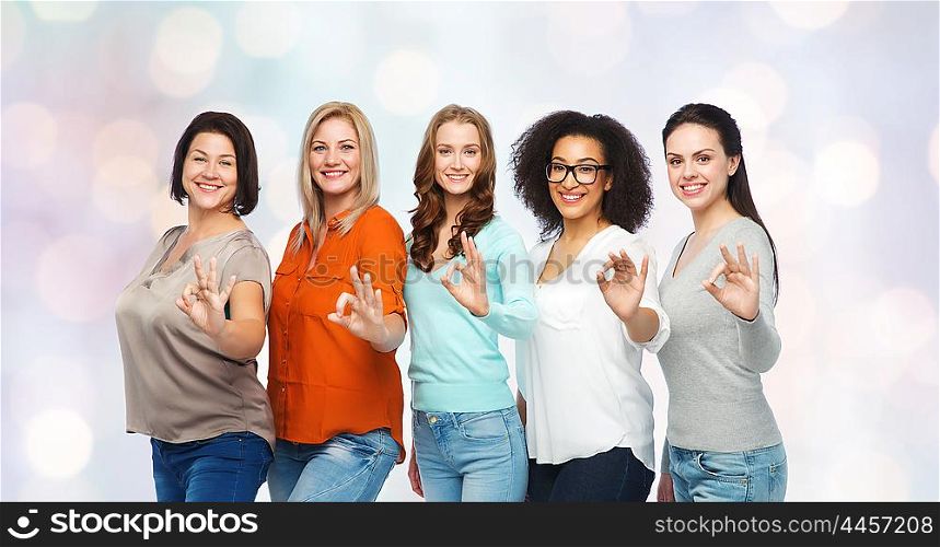 friendship, fashion, body positive, gesture and people concept - group of happy different size women in casual clothes showing ok hand sign over holidays lights background