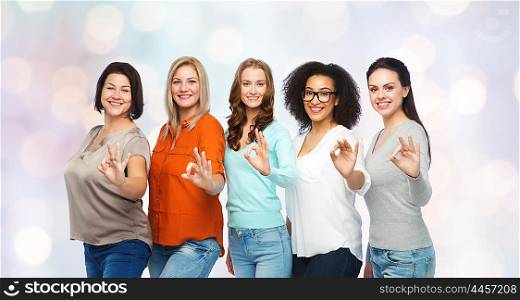 friendship, fashion, body positive, gesture and people concept - group of happy different size women in casual clothes showing ok hand sign over holidays lights background