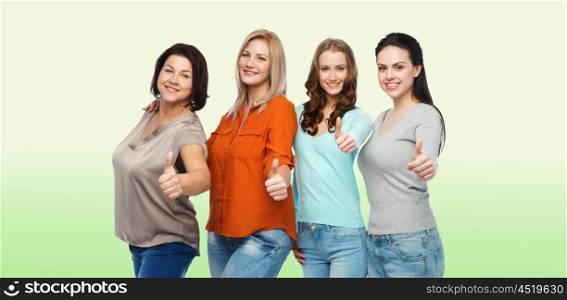 friendship, fashion, body positive, gesture and people concept - group of happy different size women in casual clothes showing thumbs up over green natural background