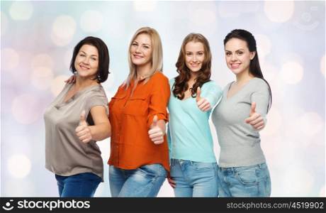 friendship, fashion, body positive, gesture and people concept - group of happy different size women in casual clothes showing thumbs up over holidays lights background