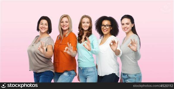 friendship, fashion, body positive, gesture and people concept - group of happy different size women in casual clothes showing ok hand sign over pink background