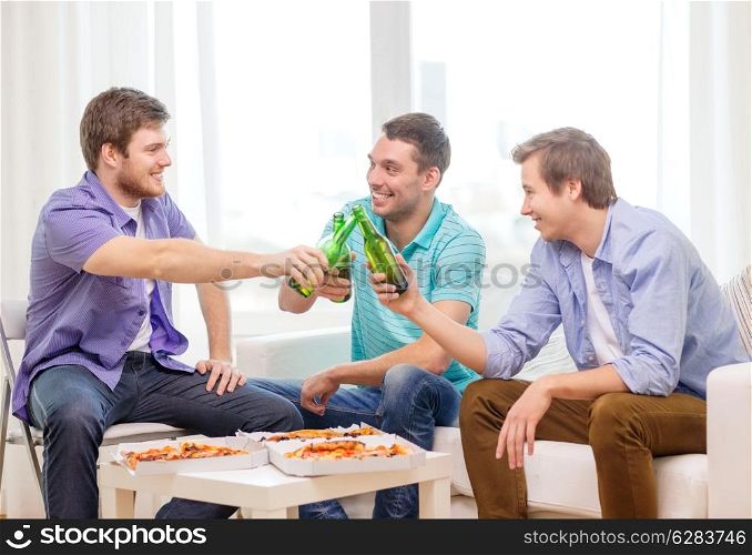 friendship, food and leisure concept - smiling male friends with beer and pizza hanging out at home