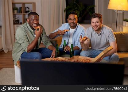 friendship, food and people concept - happy male friends with beer eating pizza and watching tv at home. happy male friends with beer eating pizza at home