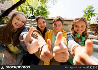 friendship, gesture and people concept - happy teenage friends or high school students showing thumbs up
